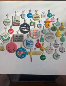 A large collection of vintage fold back metal pins buttons