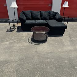 black sectional with tables and lamps