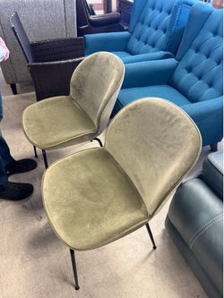 Gubi Beetle Chair is a stylish dining chair featuring a soft, curved seat upholstered in plush green velvet