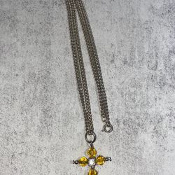 Yellow crystal cross pendant necklace   featuring golden-yellow gemstones on a silver-tone chain
