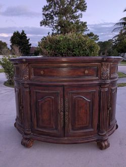 console server featuring a built-in wooden wine rack shelf, a lower solid shelf, and carved scroll feet.