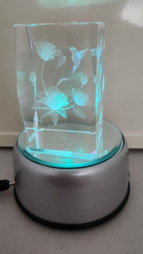 3D laser-etched crystal glass featuring a hummingbird and floral design, with a rotating light base.
