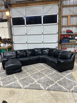 This is a large, comfortable black leather sectional with a left-side chaise. It’s super roomy, clean, and perfect for a living room, bonus room, or m