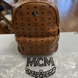 BROWN MCM BACKPACK WITH GOLD HARDWARE, EXTERIOR USED CONDITION, INTERIOR WORN CONDITION, COMES WITH MCM DUST BAG