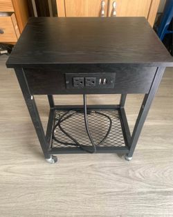 Compact little modern black end table or nightstand on wheels with power and usb outlets