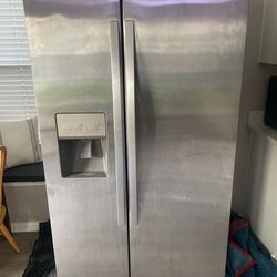 Whirlpool stainless steel side by side refrigerator with ice and water dispenser.