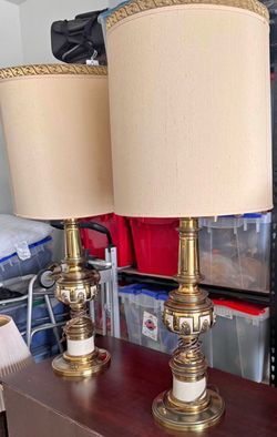 vintage Stiffel Hollywood Regency table lamps featuring a polished brass base with white enamel detailing and an ivory fabric shade.
