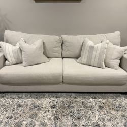 A white sofa with four cushions.