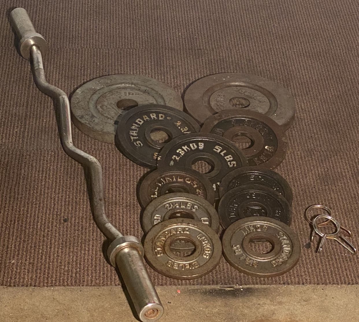74 pounds of Olympic weights and curl bar with clips
