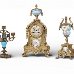 A Three Piece Clock Garniture Together With A Pair Of Three Light Candelabras