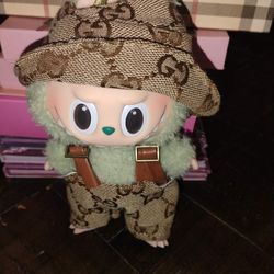 The Monsters Labubu plush toy wearing a custom, handcrafted outfit featuring a "Gucci style"