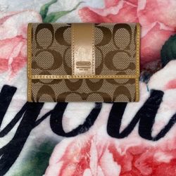 Coach Signature canvas and leather trifold wallet in a brown and tan color scheme