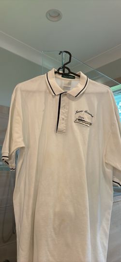 Men’s polo shirt by Outer Banks with offshore fishing boat and “Never Assume” embroidered on it