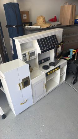 Toddler kitchen and doll house with bags of toys and accessories