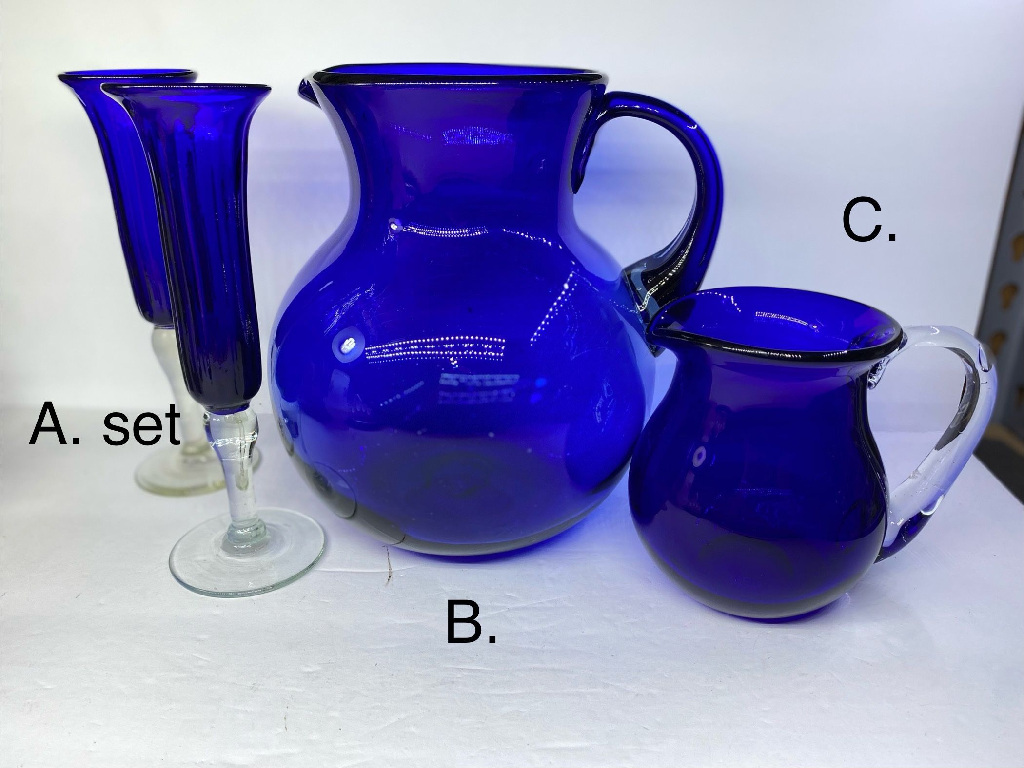 $89. For lot or priced Individually. See Description. (A) $25. Set of (2) Hand blown cobalt Blue Champagne Flutes/Flower vases W/ Clear Stems. 1 has