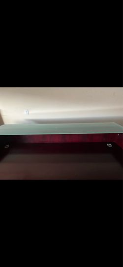This is a dark wood and glass console table, similar to some Mid-century Modern or industrial designs.