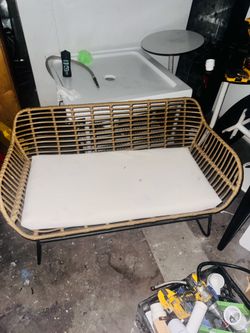 Wicker bench 2 chairs and a glass covered coffee table