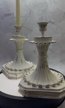 Set of (2) Vintage-style large metal candlestick holders featuring a distressed off white finish. Heavy for indoor/Outdoor use. Great for photo shoots