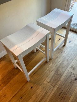 Pair of white wood counter height saddle stools