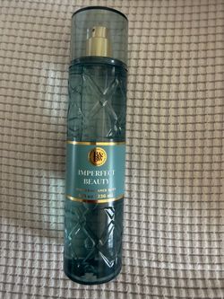 The Bath & Body Works Imperfect Beauty Fine Fragrance Mist features a textured teal-blue glass bottle with a gold cap and a warm, fruity-floral scent 