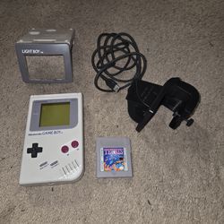 Game Boy with light attachment. Includes Tetris and NFL game cartridges.