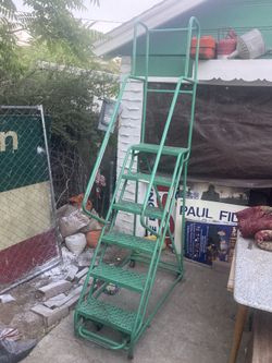 Metal warehouse ladder on wheels