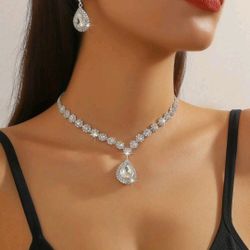 1pc white crystal necklace with matching 1 pair white crystal teardrop earrings.
Elegant silver-tone jewelry set featuring sparkling rhinestone crysta