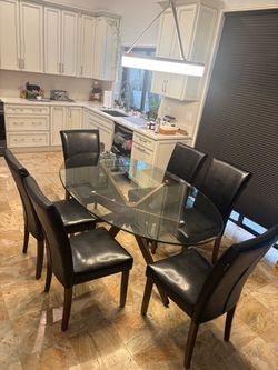 Oval glass dining table with 6 Black leather chairs