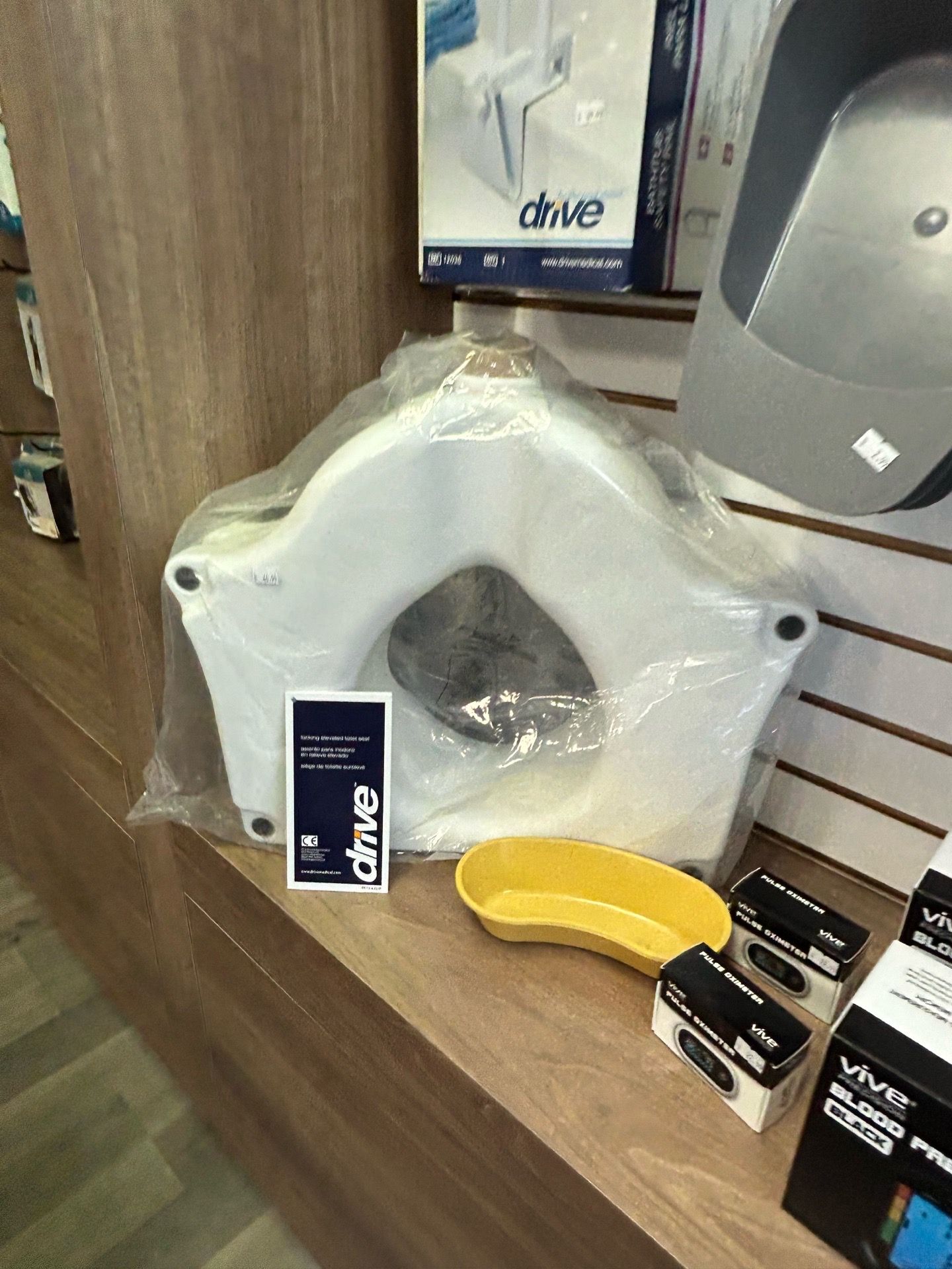 Raised toilet seat with arms for safety