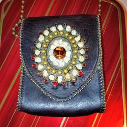 The VTG Leatherock Suede Purse is a vintage accessory designed for women who appreciate unique and eye-catching pieces. Made from green suede with a m