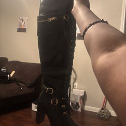 Black , thigh high, high heel boots. 