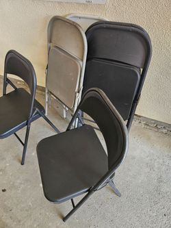 12CHAIRS FOLDING METAL IN VERY GOOD CONDITION BLACK GREY AND WHITE MIX SALE IT ALL TOGETHER HEAVY DUTY FOR ANY QUESTION TEXT ME PLEASE HABLO PLEASE