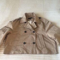 Stylish cropped trench coat in a classic beige color 