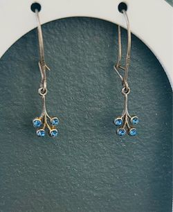 Vintage silver dangle earrings with small, light blue stones.