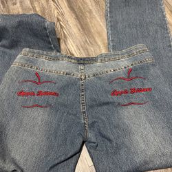 Medium wash Apple Bottom jeans with red embroidered logos on each back pocket