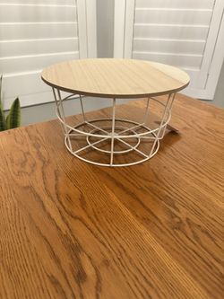 $5 - New Cute small round stand measures 11” x 6”.  Has light wood top with white wire basket base. Good for plants, displaying decor, or as little ri