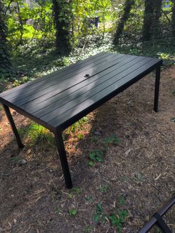 Black Metal table with hard plastic slats and umbrella hole