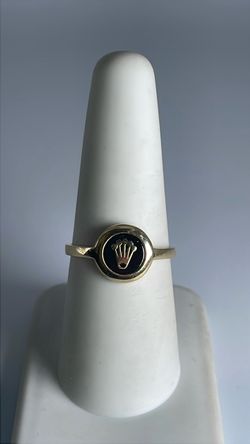 14k gold logo ring with a dark background