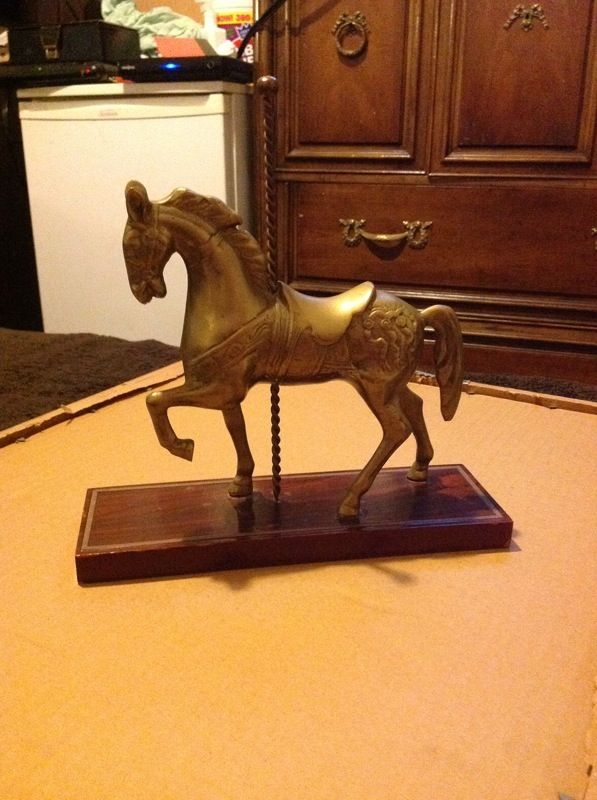 Vintage brass carousel horse on wood base