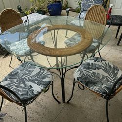 Five Piece Glass Table And Iron Chairs With Cushions