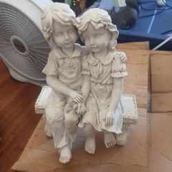 Boy and girl sitting on a bench for the flower garden $25