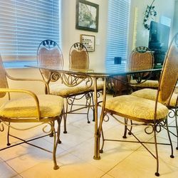 Dining Set Including sturdy Iron Table with 6 chairs.  The top is rectangular glass, the base is sturdy  iron scroll with rattan accents