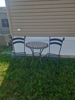 Rod iron table and chairs with a stone top.Table