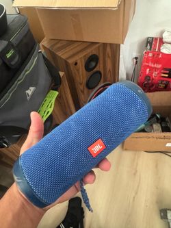 blue JBL Flip 4 portable Bluetooth speaker.