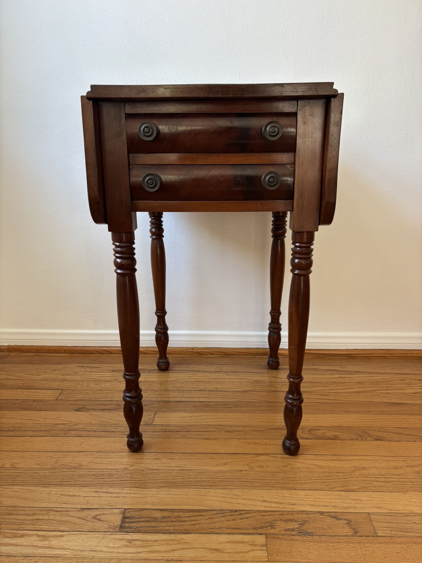Antique mahogany drop-leaf side table with two drawers and turned legs
