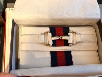 White leather Gucci wallet with central horsebit detail over a red and blue web stripe.- New in box