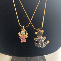 Set of 2 17" Gold Toned Necklaces One Pink Jewel Accented Angel Pendant and One Clear Glass Bear Pendant. Angel has unknown markings. Fashionable Cost