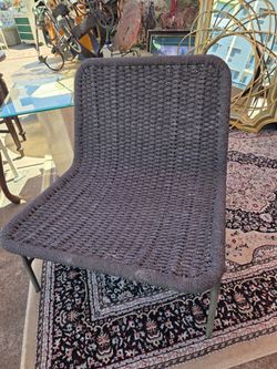 Modern-design armless chair featuring a dark gray woven rope or cord seat and backrest.