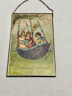 This is a vintage, embossed birthday postcard featuring children on a floral swing, likely dating from the early 20th century. 