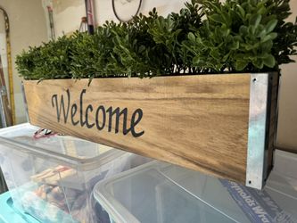 Welcome Sign And Fake Plant